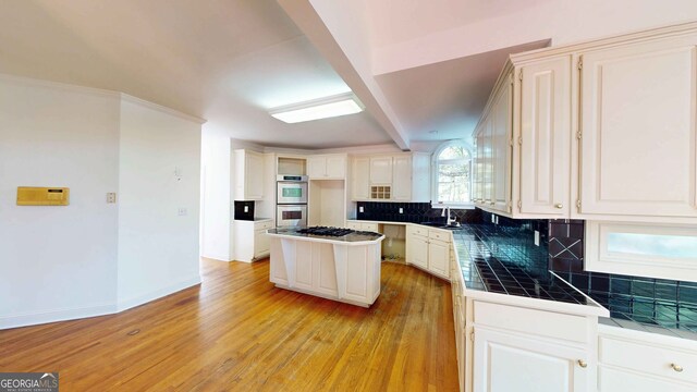 15 Greenridge Way, Newnan, GA 30265 - kitchen with tile countertops, tasteful backsplash, white cabinets, light wood-style floors, and ornamental molding