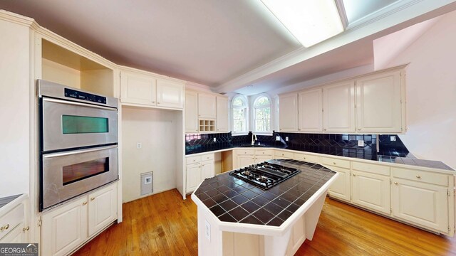 15 Greenridge Way, Newnan, GA 30265 - kitchen with decorative backsplash, tile counters, light wood-type flooring, and stainless steel double oven