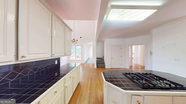 15 Greenridge Way, Newnan, GA 30265 - kitchen with tile countertops, tasteful backsplash, white cabinets, light wood-style floors, and ornamental molding