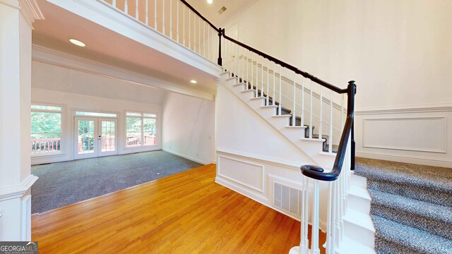 15 Greenridge Way, Newnan, GA 30265 - stairway featuring wood finished floors, ornamental molding, a decorative wall, and french doors