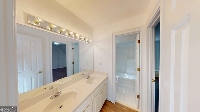 15 Greenridge Way, Newnan, GA 30265 - full bath featuring double vanity, a sink, wood finished floors, and toilet