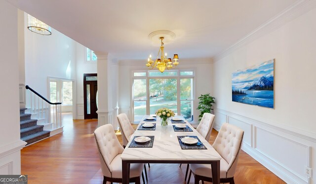15 Greenridge Way, Newnan, GA 30265 - unfurnished dining area featuring a decorative wall, a notable chandelier, stairway, and light wood-type flooring