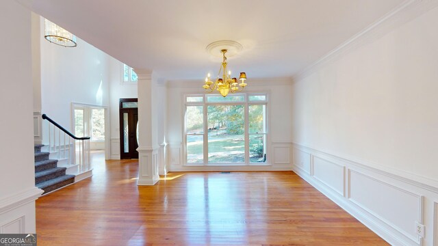 15 Greenridge Way, Newnan, GA 30265 - unfurnished dining area featuring light wood-type flooring, a decorative wall, a chandelier, and stairway