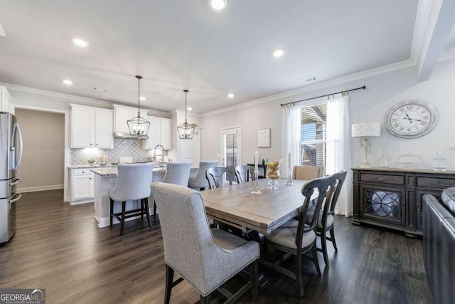 dining space with dark wood-type flooring, sink, and crown molding