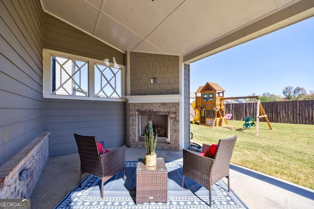 view of patio with a playground and an outdoor brick fireplace