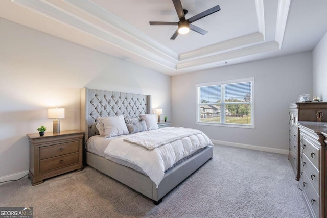 carpeted bedroom featuring a tray ceiling, ceiling fan, and crown molding