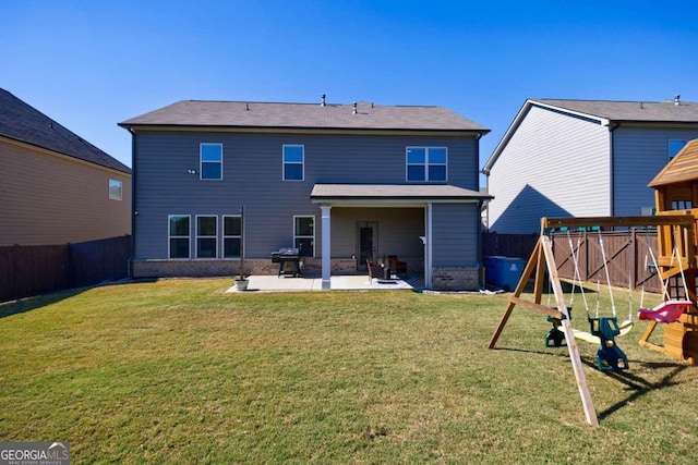 rear view of house with a playground, a patio, and a yard