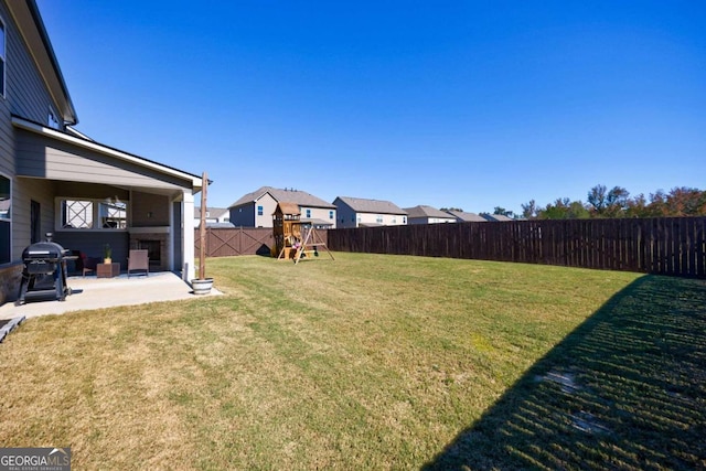 view of yard featuring a playground and a patio area