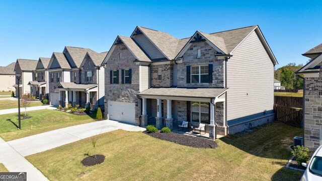 view of front of property with a garage, a front yard, and covered porch