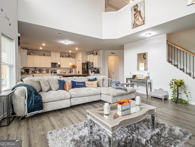 living room featuring a high ceiling and hardwood / wood-style flooring