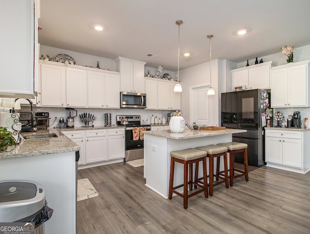 kitchen featuring white cabinetry, appliances with stainless steel finishes, and a center island