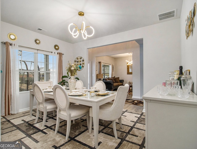 dining room featuring light hardwood / wood-style flooring and a chandelier