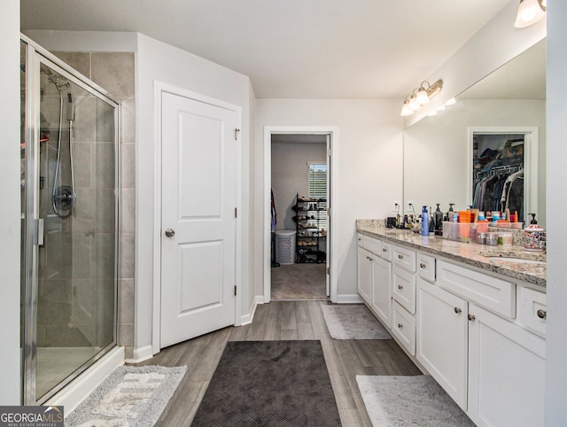 bathroom featuring an enclosed shower, vanity, and hardwood / wood-style flooring