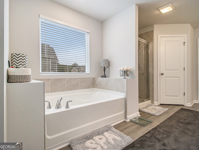 bathroom with hardwood / wood-style flooring and independent shower and bath