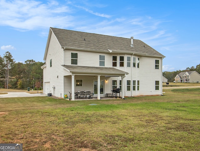 rear view of house featuring a patio, central AC, and a yard