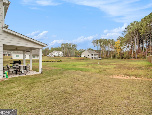 view of yard with ceiling fan and a patio