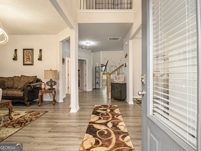 entrance foyer featuring hardwood / wood-style floors and ornate columns