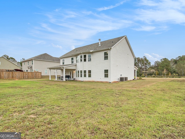 rear view of house with central AC unit, a lawn, and a patio area