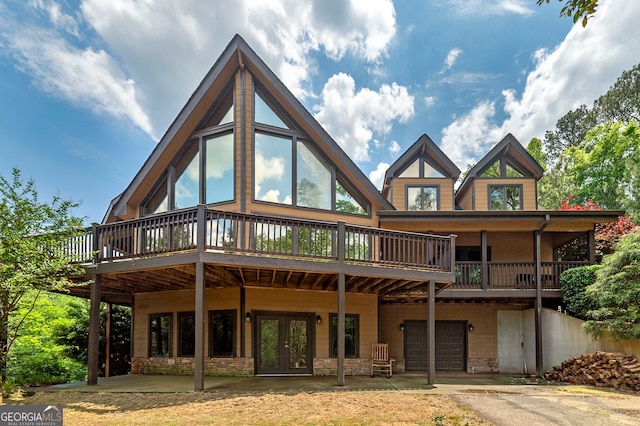 rear view of property with a wooden deck and a garage