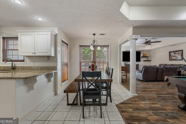 tiled dining area featuring sink, a textured ceiling, decorative columns, ceiling fan, and billiards