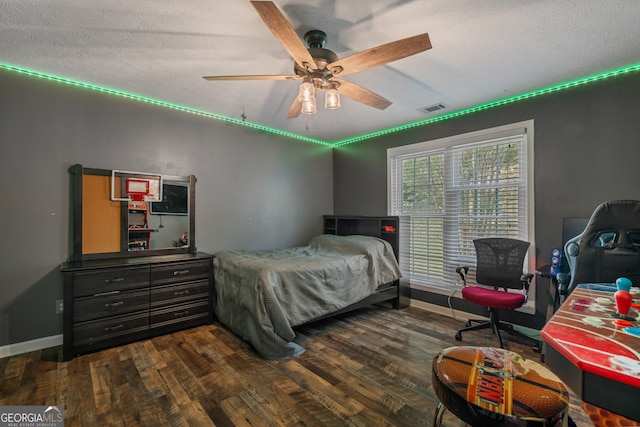 bedroom featuring ceiling fan, a textured ceiling, and dark hardwood / wood-style flooring