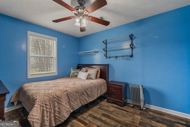 bedroom featuring a textured ceiling, dark hardwood / wood-style floors, radiator heating unit, and ceiling fan