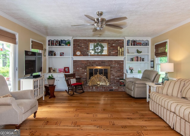 7 Stonehaven Dr, Newnan, GA 30265 - living area with wood finished floors, ceiling fan, built in shelves, ornamental molding, and a brick fireplace