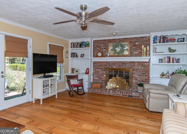 living room with light hardwood / wood-style floors, crown molding, a textured ceiling, and ceiling fan