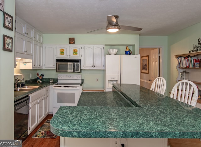 kitchen with a textured ceiling, dark hardwood / wood-style floors, sink, a center island, and white appliances