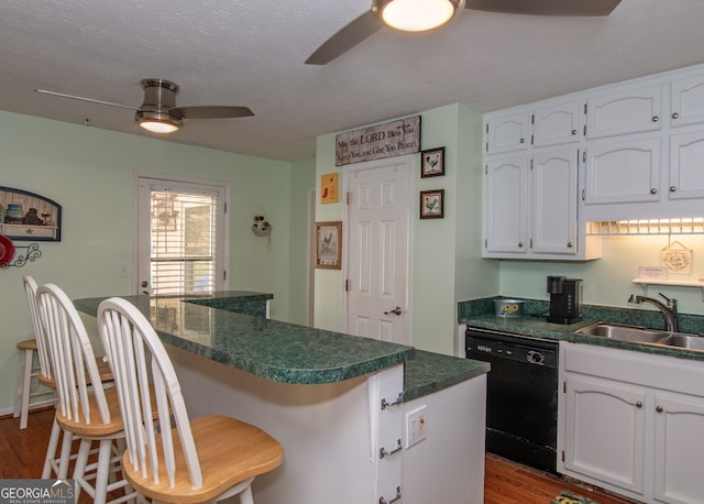 kitchen with sink, black dishwasher, a breakfast bar area, and light hardwood / wood-style flooring