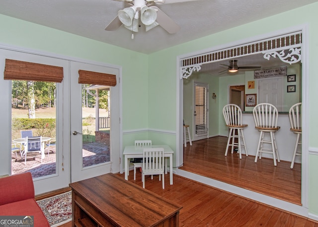 dining space featuring a textured ceiling, hardwood / wood-style flooring, and ceiling fan