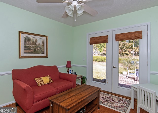 living room featuring french doors, a textured ceiling, wood-type flooring, and ceiling fan