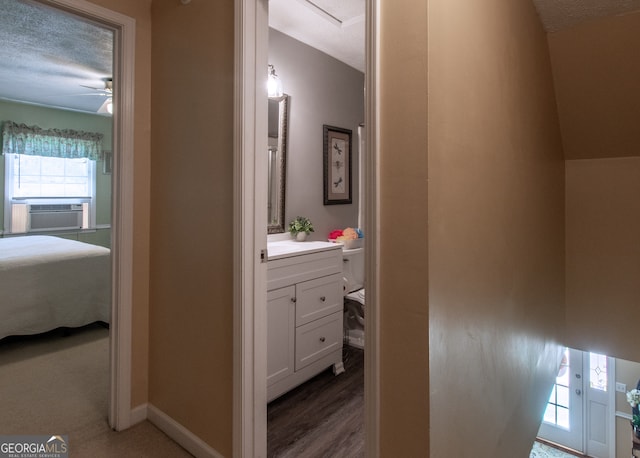 bathroom with cooling unit, wood-type flooring, vanity, a textured ceiling, and ceiling fan