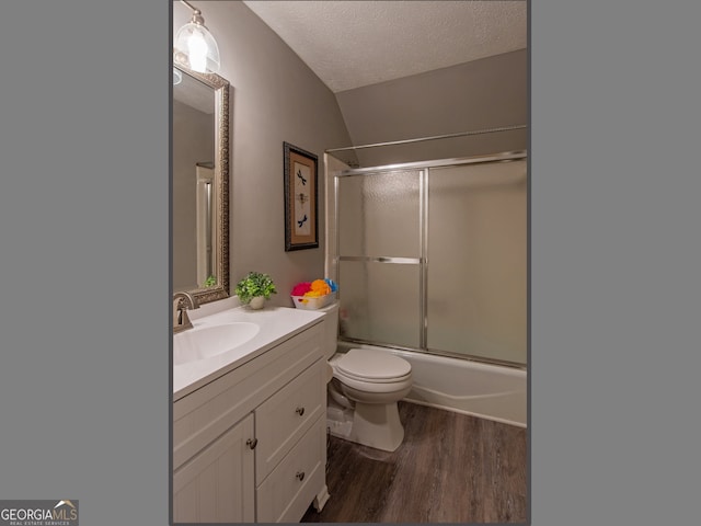 full bathroom featuring toilet, hardwood / wood-style floors, vanity, a textured ceiling, and shower / bath combination with glass door