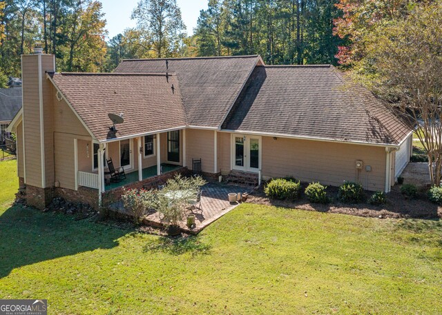 rear view of property featuring a patio and a yard