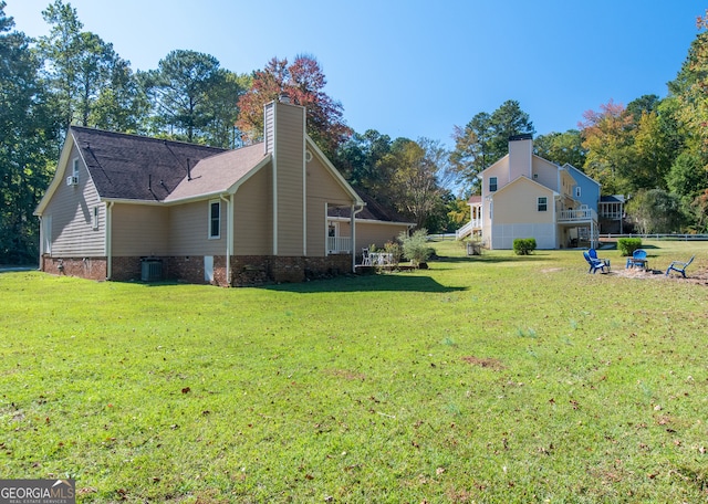 view of side of home with central air condition unit, a deck, and a lawn