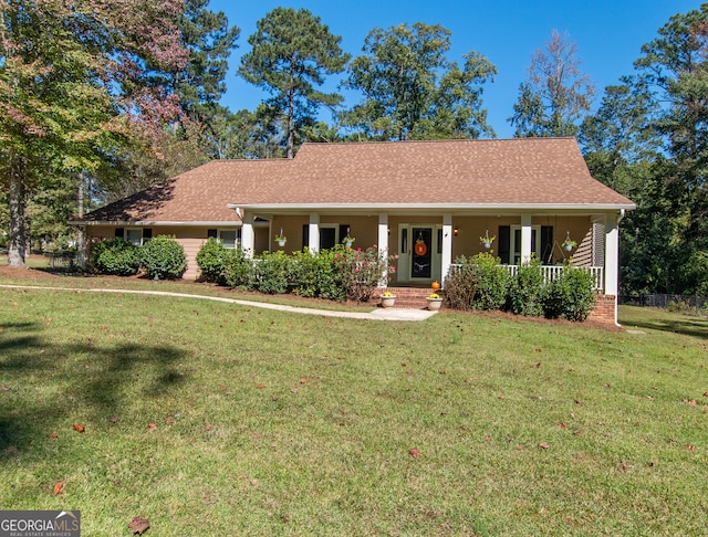 ranch-style home featuring covered porch and a front lawn