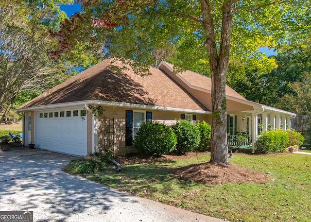 view of front of house featuring a porch, a front lawn, and a garage