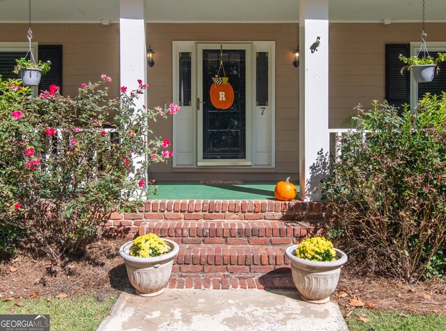 view of exterior entry with a porch