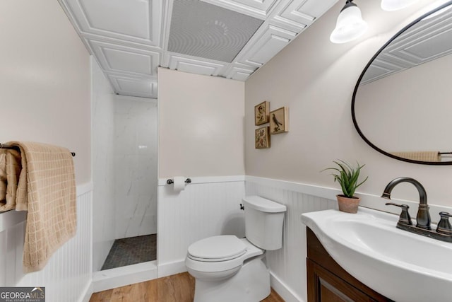 bathroom with toilet, a shower, vanity, and wood-type flooring