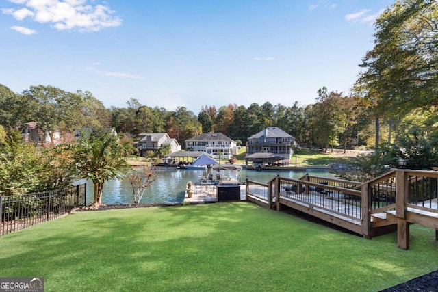 view of dock with a water view and a lawn