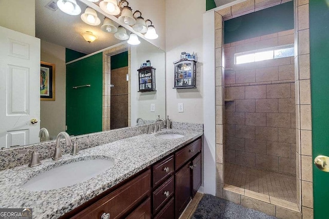 bathroom with vanity and a tile shower