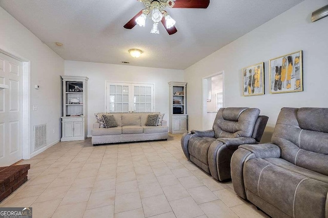 living room featuring ceiling fan, a textured ceiling, and light tile patterned floors