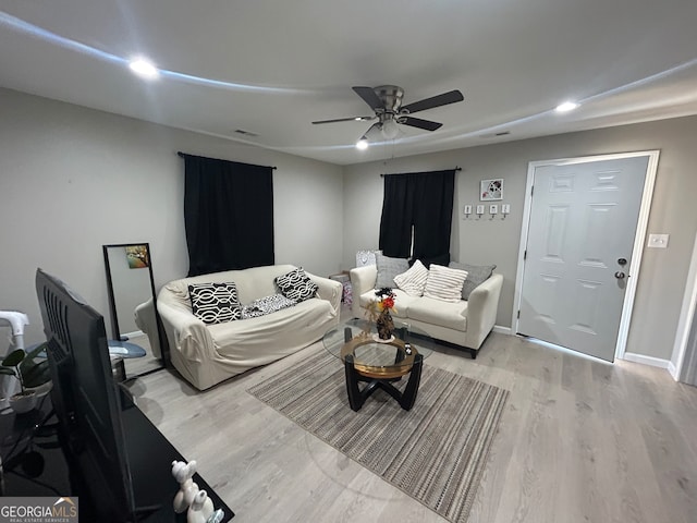 living room featuring light hardwood / wood-style flooring and ceiling fan