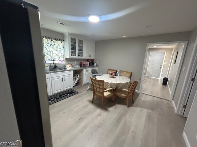 dining room with light hardwood / wood-style floors and sink