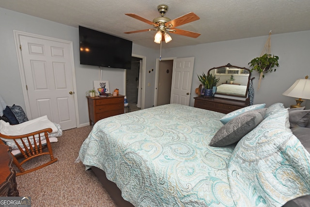 carpeted bedroom featuring a textured ceiling and ceiling fan