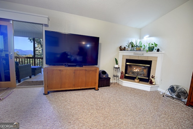 living room featuring vaulted ceiling, light carpet, and a tile fireplace