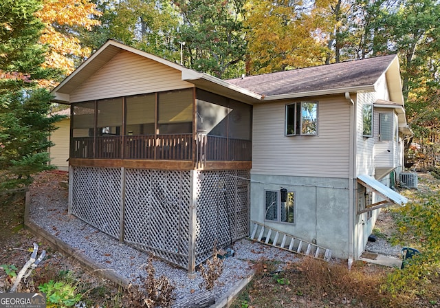 rear view of property featuring central AC and a sunroom