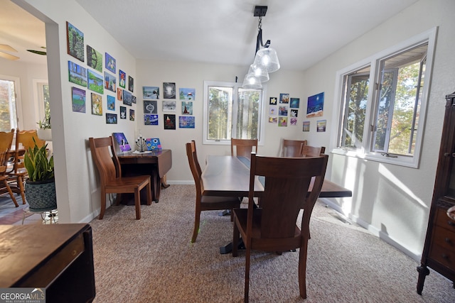 carpeted dining room featuring ceiling fan