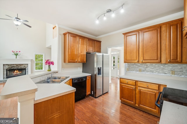 kitchen featuring black appliances, sink, kitchen peninsula, crown molding, and light hardwood / wood-style flooring